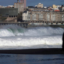 Una mujer observa las olas desde el paseo marítimo de A Coruña.