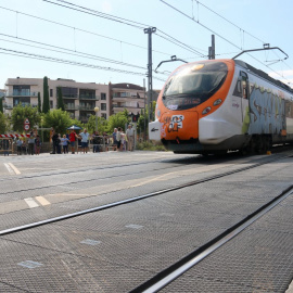 10/09/2024 - Un tren de Rodalies circula per Montcada i Reixac al costat d'un pas a nivell.