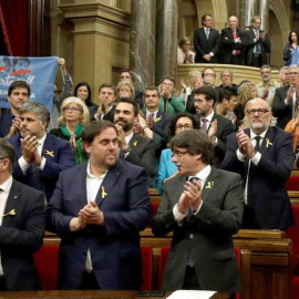 Carles Puigdemont y Oriol Junqueras, aplauden junto a los diputados de JxSí y la CUP. EFE