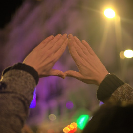 Una mujer hace el histórico gesto feminista durante la marcha del 25N por Madrid.