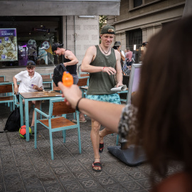 Una dona dispara una pistola d'aigua contra uns turistes en un restaurant de menjar ràpid