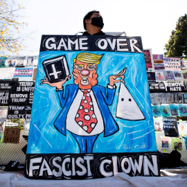 Un ciudadano porta carteles contra el todavía presidente de EEUU, Donald Trump, cerca de la Casa Blanca (Washington).