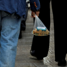 un hombre lleva una bolsa con monedas, en Ronda (Málaga). REUTERS/Jon Nazca