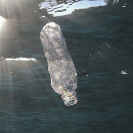 Imagen de una botella de plástico en el mar.