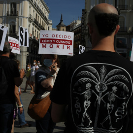 Un grupo de personas se reúne sosteniendo pancartas y carteles durante la concentración de la asociación Derecho a Morir Dignamente (DMD) en la Puerta del Sol