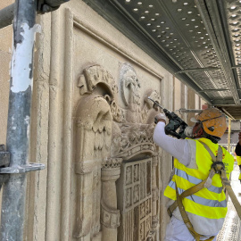 Unos operarios eliminan del edificio del antiguo Palacio de Justicia de Vitoria el último escudo de la época franquista que quedaba visible en las calles de la ciudad.