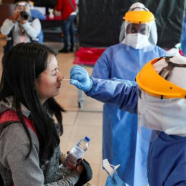 Personal médico realiza pruebas PCR en un aeropuerto