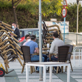 Camareros de un bar de Mairena del Aljarafe(Sevilla) recogen el mobiliario para proceder al cierre antes de las seis de la tarde