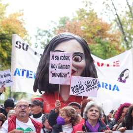 Varias personas portan una cabezuda con la cara de Ayuso durante una manifestación contra el desmantelamiento de la Atención Primaria en la columna que ha salido de Atocha, a 13 de noviembre de 2022, en Madrid.