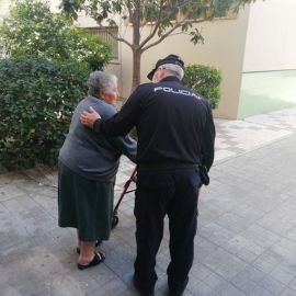 Un agente ayuda a una mujer mayor. - Twitter de la Policía Nacional