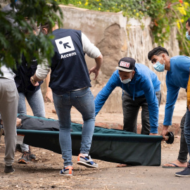 Unos inmigrantes y personal de la ONG Accem, que gestiona el campamento humanitario de Las Raíces, trasladan a uno de los heridos en los altercados.