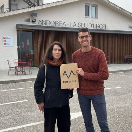 Dos portaveus de la nova plataforma amb el cartell de l'organització a l'exterior de la terminal de l'aeroport d'Andorra - La Seu d'Urgell