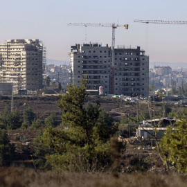 Nuevos edificios de apartamentos en construcción en el asentamiento de Beit El en la ocupada Cisjordania con la ciudad palestina de Ramallah al fondo.