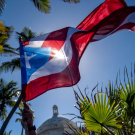 Imagen de archivo de una bandera puertorriqueña frente al edificio del Capitolio durante una protesta de maestros que exigen mejoras salariales, en San Juan, Puerto Rico, el 9 de febrero de 2022.