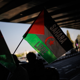 Una de las personas que apoya a los saharauis retenidos con una bandera del 'Sahara Libre', en la Terminal T1 de Barajas, a 23 de septiembre de 2024, en Madrid.