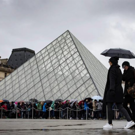 Turistas ante el museo del Louvre, en París. / IAN LANGSDON (EFE)