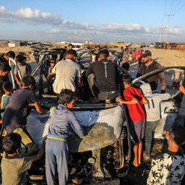 30/09/2024 | Niños palestinos se reúnen alrededor de un automóvil destruido por aviones de combate israelíes, en Khan Yunis (Franja de Gaza).