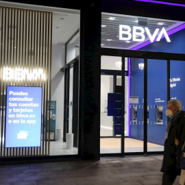 Una pareja pasa frente a una oficina del BBVA, en Bilbao. EFE/LUIS TEJIDO