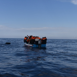 Imagen de archivo de varias personas migrantes en un bote de madera, antes de ser rescatadas por la ONG Open Arms.