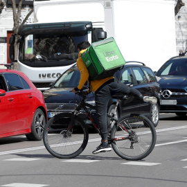 Un repartidor de una plataforma digital circula en bici en Madrid.