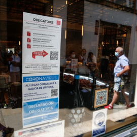 Carteles en diferentes idiomas de indicaciones de obligatoriedad de presentar certificados antes de acceder al interior, en una marisquería de la Rua do Franco, el día en que el TSXG declara nula la petición de certificado Covid para entrar en hosteler