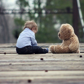 Foto de archivo de un niño con un oso de peluche.