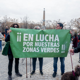 Varias personas portan una pancarta que reza 'En lucha por nuestras zonas verdes' en la concentración para defender la arboleda de la zona de Madrid Río, que se verá afectada por las obras del Metro, a 18 de febrero de 2023, en Madrid (España).