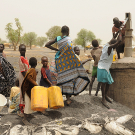 Mujeres y niños recogen agua de un pozo en un campamento de Sudán del Sur.REUTERS / Jok Solomun