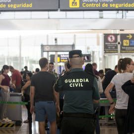 Un agente de la Guardia Civil en un control de seguridad del Aeropuerto de Barcelona-El Prat, donde se han vuelto a registrar colas de hasta una hora. EFE/Quique García