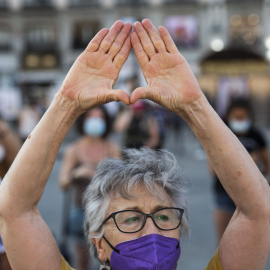 Una mujer levanta las manos en una concentración para exigir “El Pacto de Estado Contra la Violencia de Género”, a 6 de agosto de 2021, en la Puerta del Sol.