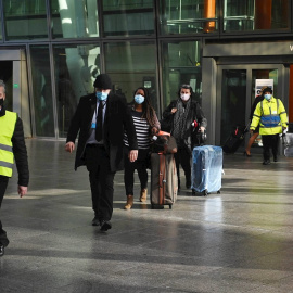 Viajeros internacionales son escoltados a su llegada al aeropuerto londinense de Heathrow hasta el Radison Blu Hotel, donde tienen que hacer cuarentena.