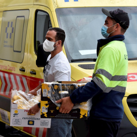 Dos voluntarios llevan al pabellón deportivo de Los Llanos de Aridane comida donada por empresa de La Palma para las familias desplazadas de sus viviendas por la erupción del volcán.