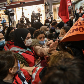 Manifestantes chocan con agentes de policía cuando intentan pasar la barricada para seguir marchando por la avenida Istiklal, la principal calle comercial de Estambul, durante una manifestación del 25N.