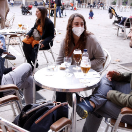 Unos joves prenent una cervesa tomando a la plaça de la Virreina (Barcelona).