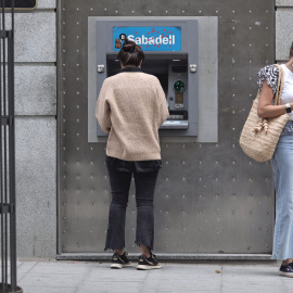 Dos mujeres en un cajero de una sucursal de banco Sabadell. Foto de archivo.