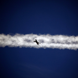 Un avión vuela debajo de la estela de vapor de otro avión sobre la ciudad italiana de Padua.