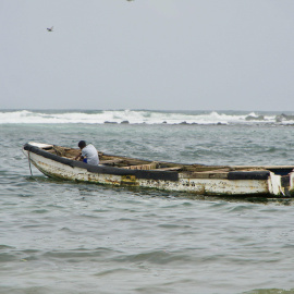 Niño sentado en una 'pirogue', mejor conocido como cayuco, en la playa de Yoff Thongor, Dakar