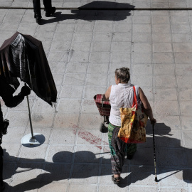 Una mujer tras ser desalojada del edificio Dignidad de Móstoles junto a un agente de Policía Nacional.