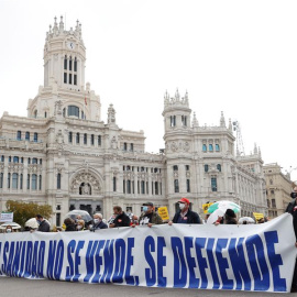 Participantes tras una pancarta en la manifestación de la Marea blanca en defensa de la sanidad pública que tiene lugar este domingo en Madrid, entre Neptuno y la plaza de Colón.