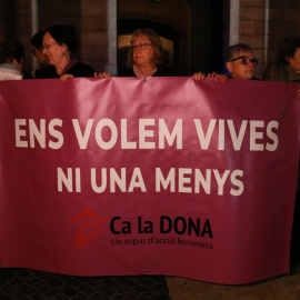 Diverses dones subjectant una pancarta a la concentració convocada a la plaça Sant Jaume de Barcelona.