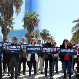 Diversos independentistes espiats per Pegasus en el 'Catalangate' mostren cartells contra l'espionatge davant de l'hotel Vela de Barcelona.