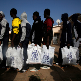 Un grupo de personas migrantes, de origen gambiano, se embarca en un vuelo de retorno voluntario a su países desde Libia, gestionado por la OIM.- REUTERS/Luc Gnago/File Photo