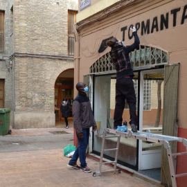 Una graffitera pinta la mañana de este lunes el rótulo de la tienda del top manta de Zaragoza.