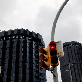 Un semáforo en rojo delante de los edificios centrales de Caixabank en Barcelona. REUTERS/Nacho Doce