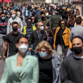 Cientos de personas caminan por el paseo marítimo de la Malvarrosa de València.