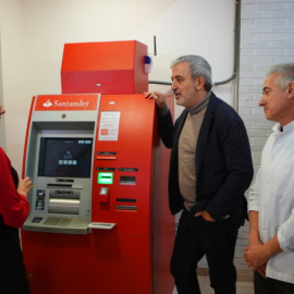 El tinent d'alcaldia d'Economia de Barcelona, Jaume Collboni, amb el president del Mercat del Besòs, Joaquim Tomás, i la propietària d'una parada de llegums, Lourdes Mulero, amb el caixer bancari instal·lat en aquest equipament.