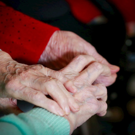 03/12/2020. Imagen de archivo de dos personas mayores cogidas de la mano. - EFE