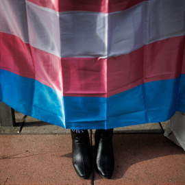 Los zapatos de una mujer debajo de una bandera trans durante una concentración de la Federación Plataforma Trans, a 28 de octubre de 2022, en Madrid.