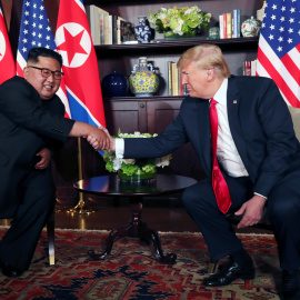 Kim Jong Un y Donald Trump estrechan sus manos antes de su conversación privada enmarcada en la cumbre celebrada en el Hotel Capella de la isla de Sentosa (Singapur). /REUTERS