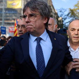 El expresident Carles Puigdemont, rodeado de dirigentes de Junts, abandona el escenario tras una breve intervención en su reaparición en Barcelona tras siete años de exilio. REUTERS/Nacho Doce